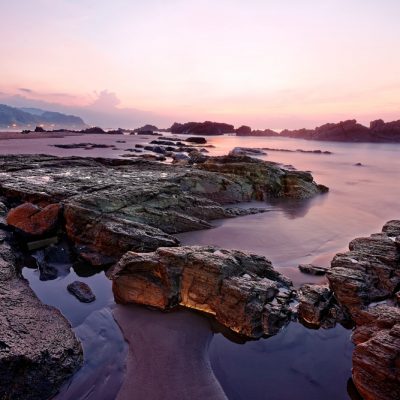 Beautiful sunrise sky reflecting on the peaceful sea water at the rocky beach of Yilan Coast Geologic Park